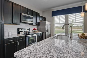 kitchen with granite counter tops and black cabinets and stainless steel appliances  at Watermark on Twenty Mile, Parker, Colorado